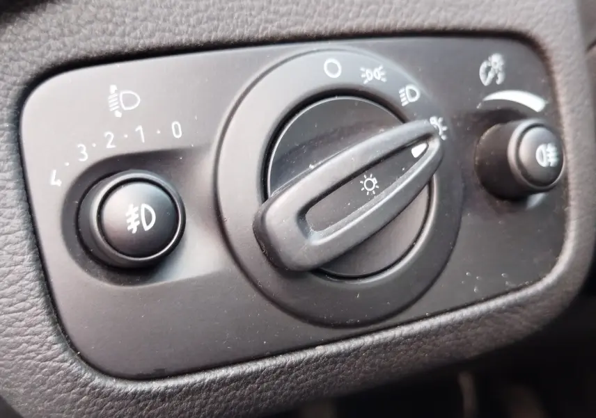 Gros plan sur le bouton de commande des phares du Ford Kuga gris clair, avec réglage des feux et antibrouillards.