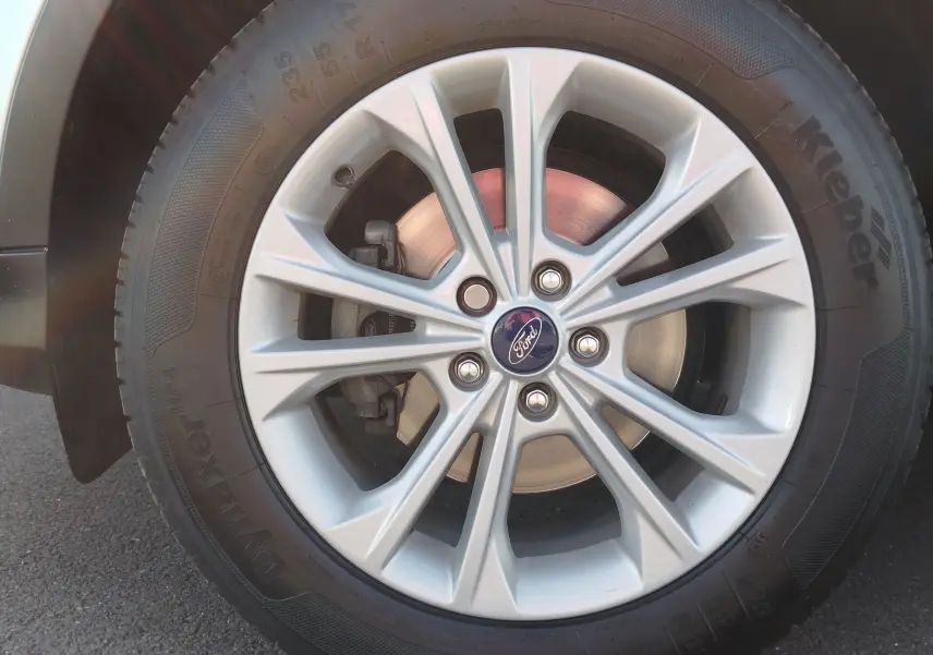 Gros plan sur la jante alliage argentée et pneu Kleber du Ford Kuga gris clair, côté avant droit.