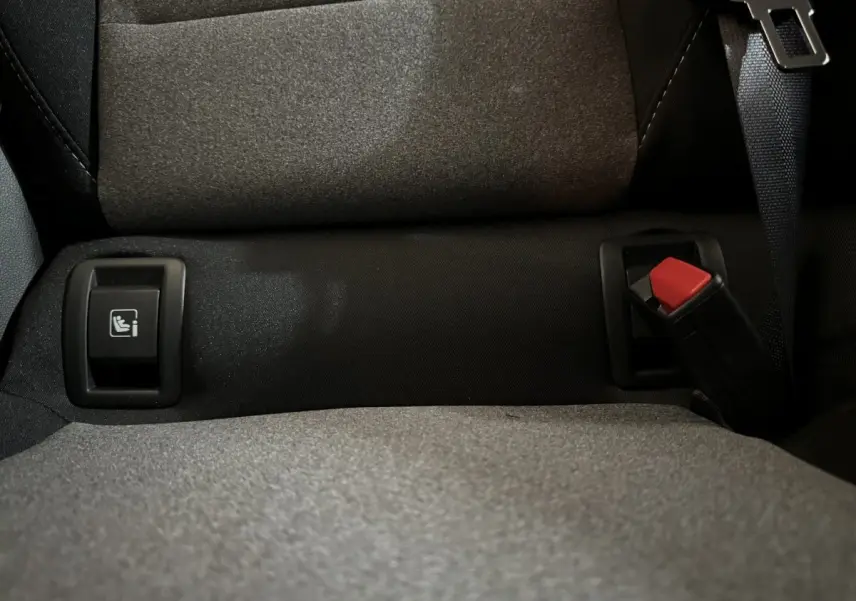 Gros plan sur la banquette arrière grise de la Renault Clio 2025 avec ceinture et bouton Isofix visibles.