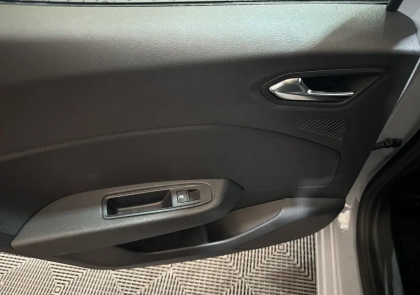 Vue rapprochée de la porte avant droite gris clair de la Renault Clio 2025 avec poignée et commande de vitre électrique.