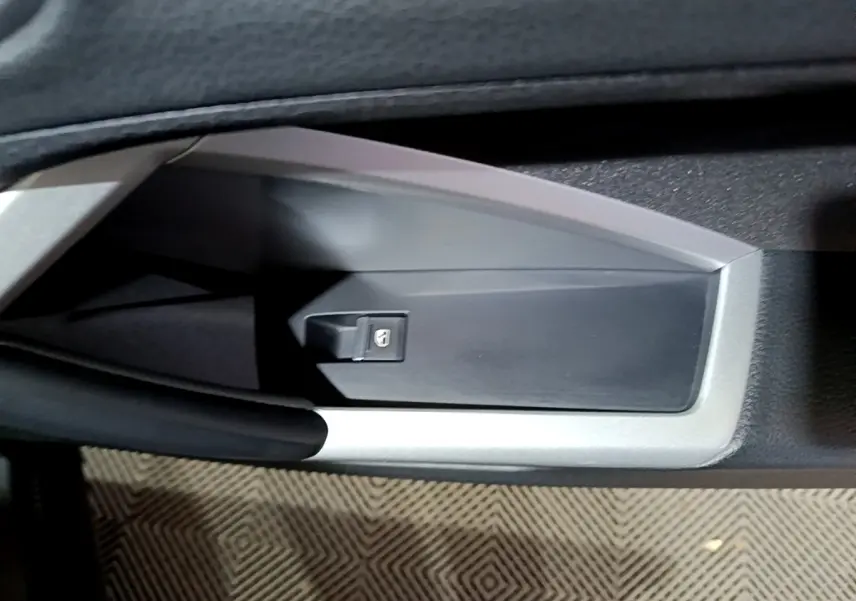 Détail de la commande de lève-vitre côté conducteur sur la porte intérieure d’un Audi Q3 noir 2020.