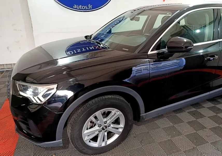 Vue 3/4 avant gauche d'un Audi Q3 noir avec jantes alliage et rétroviseur noir brillant.