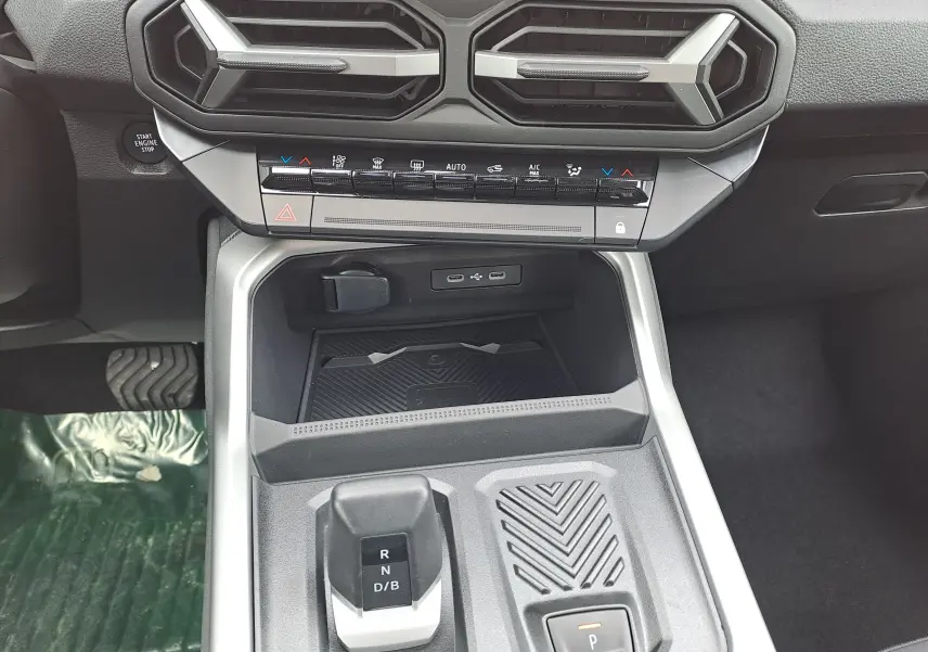 Vue rapprochée de la console centrale intérieure grise du Dacia Bigster Hybrid 155 avec levier de vitesses automatique et commandes climatisation.