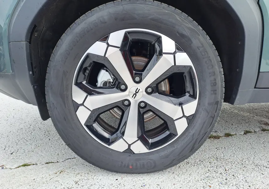 Gros plan sur la roue avant droite du Dacia Bigster vert cèdre, mettant en valeur la jante bicolore moderne.