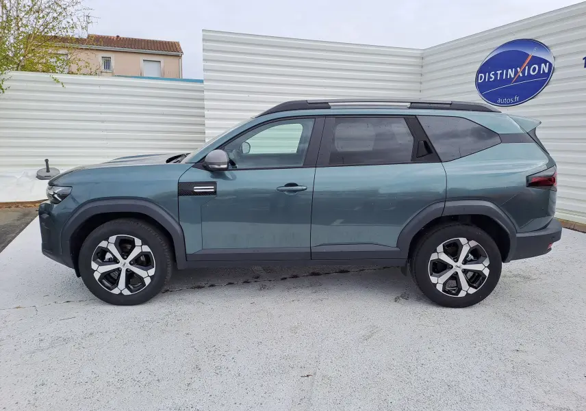 Vue de profil côté gauche du SUV Dacia Bigster vert cèdre 2026 avec jantes bi-ton et toit noir.