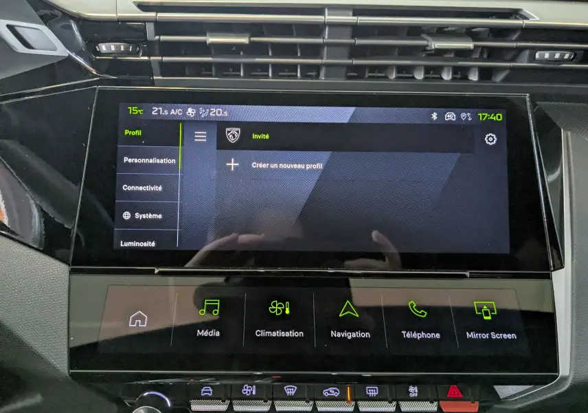 Écran tactile central de la Peugeot 408 Hybrid 145 GT 2025, affichant le menu profil, entouré de commandes tactiles et boutons argentés.