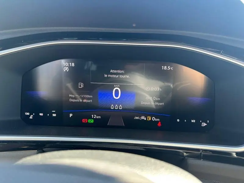Vue rapprochée du tableau de bord numérique du Volkswagen T-Roc 2025, affichage en mode veille moteur, fond noir avec détails bleus.