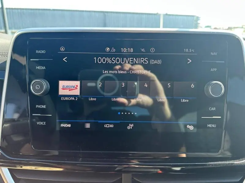 Écran tactile central du Volkswagen T-Roc 2025 affichant la radio DAB sur fond noir brillant.