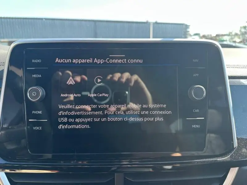 Écran tactile central du Volkswagen T-Roc 2025 affichant le message de connexion App-Connect, entouré de commandes noires.