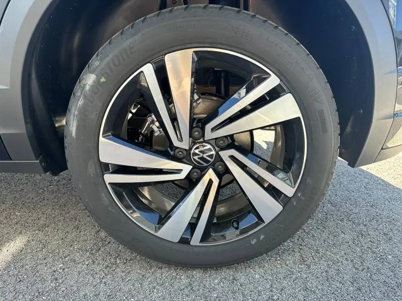 Gros plan sur la jante alliage bicolore noire et argentée avec logo Volkswagen, montée sur un pneu Bridgestone.