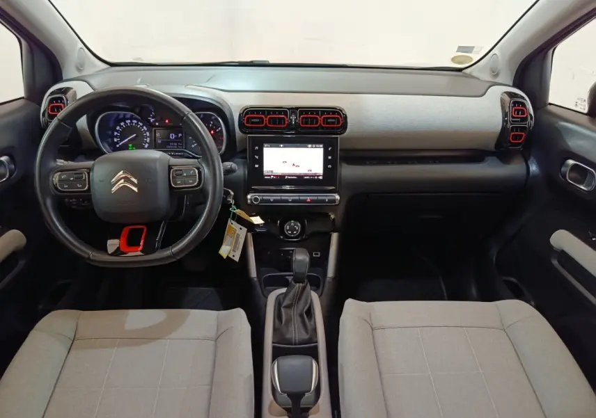 Vue intérieure avant du Citroën C3 Aircross beige 2021, tableau de bord moderne avec écran tactile central et volant cuir.