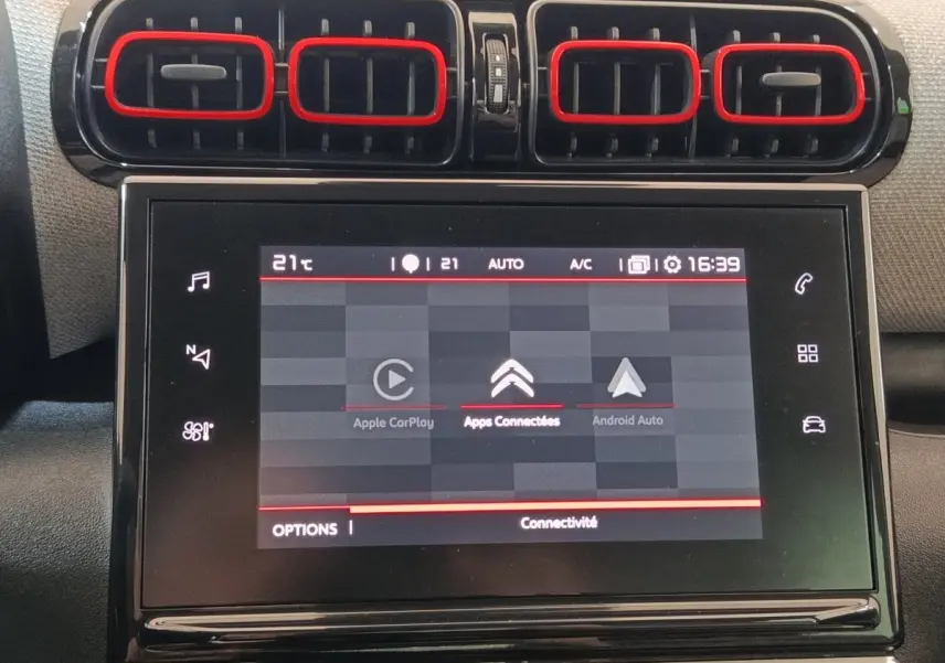 Vue rapprochée de la console centrale noire avec écran tactile et aérateurs rectangulaires du Citroën C3 Aircross beige.