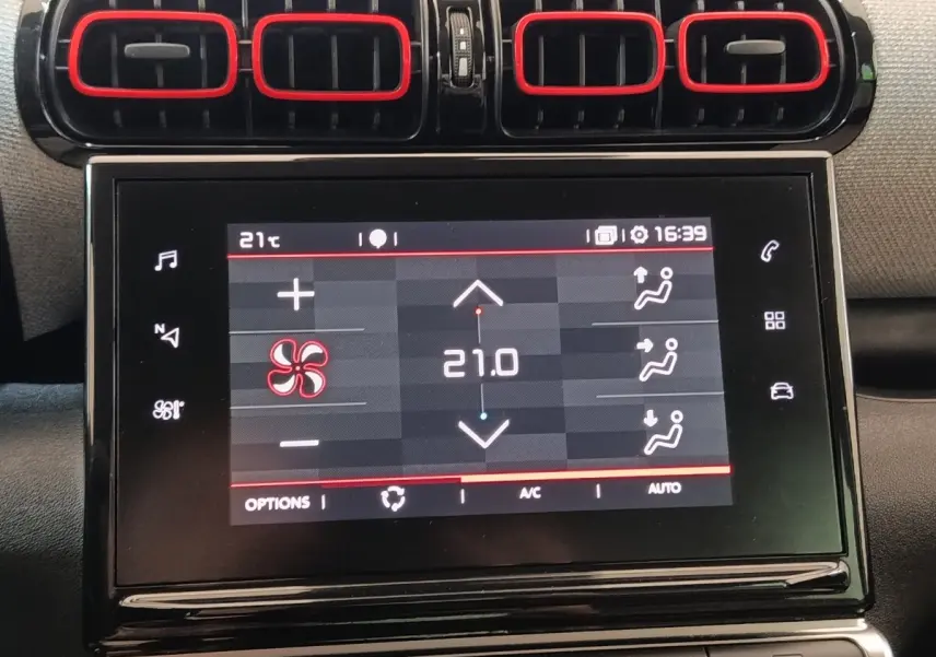 Écran tactile central et quatre aérateurs noirs avec contours rouges dans l’habitacle d’une Citroën C3 Aircross beige.
