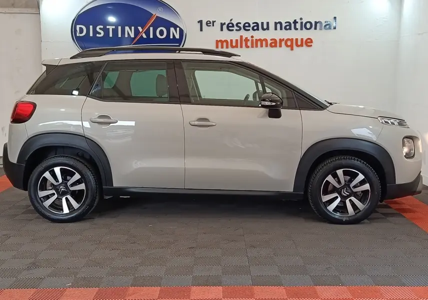 Profil latéral droit d'une Citroën C3 Aircross beige 2021 avec toit noir et jantes alliage bicolores.