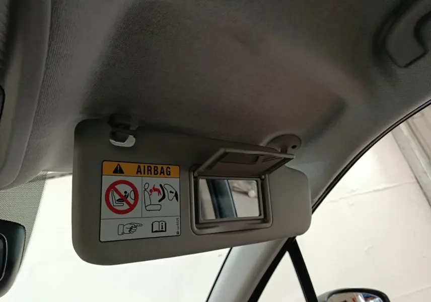 Détail du pare-soleil côté conducteur avec miroir intégré et avertissement airbag dans une Citroën C3 Aircross beige.