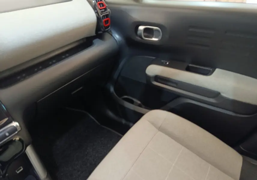 Vue intérieure côté passager avant du Citroën C3 Aircross beige, avec tableau de bord et garnitures grises.