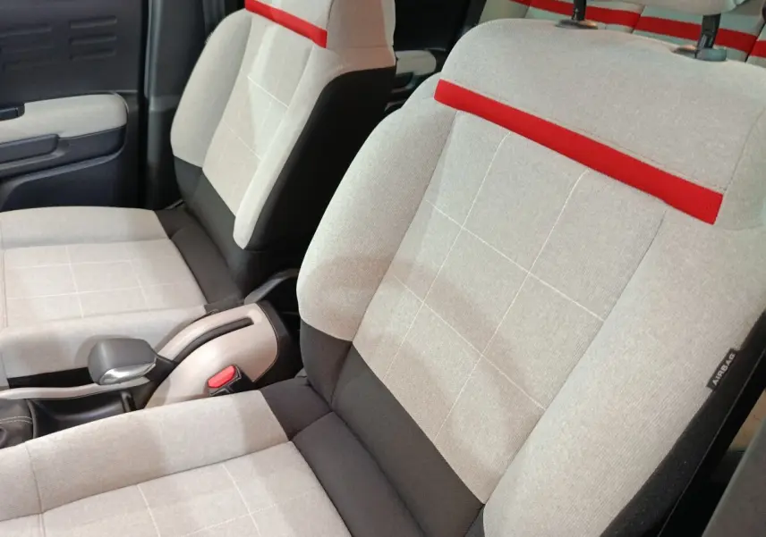 Gros plan sur les sièges avant gris clair avec bande rouge et détails noirs de la Citroën C3 Aircross Shine 2021.