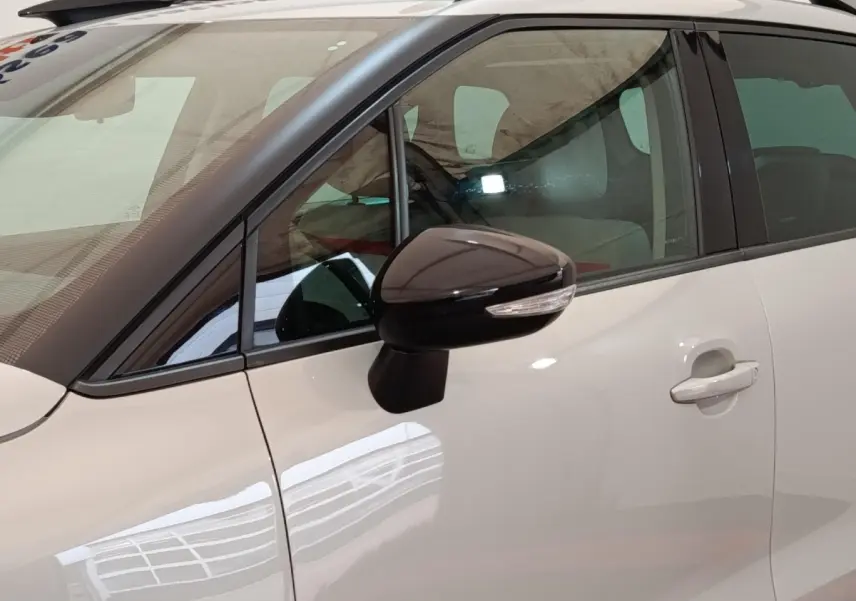 Vue latérale côté gauche d'une Citroën C3 Aircross beige avec rétroviseur noir et toit blanc.
