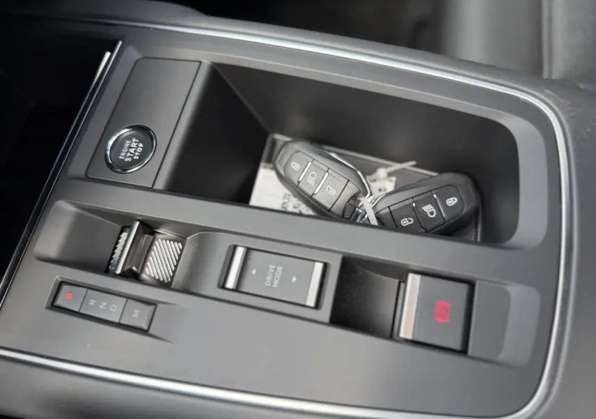 Gros plan sur la console centrale du Citroën C5 Aircross 1.5 HDi 130 EAT8 Max avec clés et bouton start/stop.
