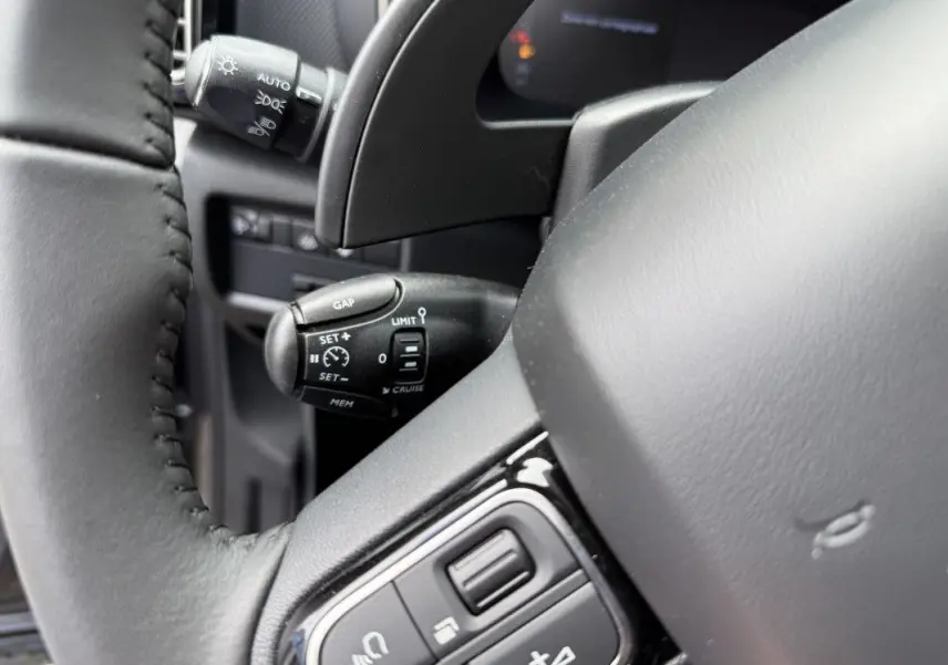 Gros plan sur le volant et la commande de régulateur de vitesse du Citroën C5 Aircross 1.5 HDi 130 gris platinium.
