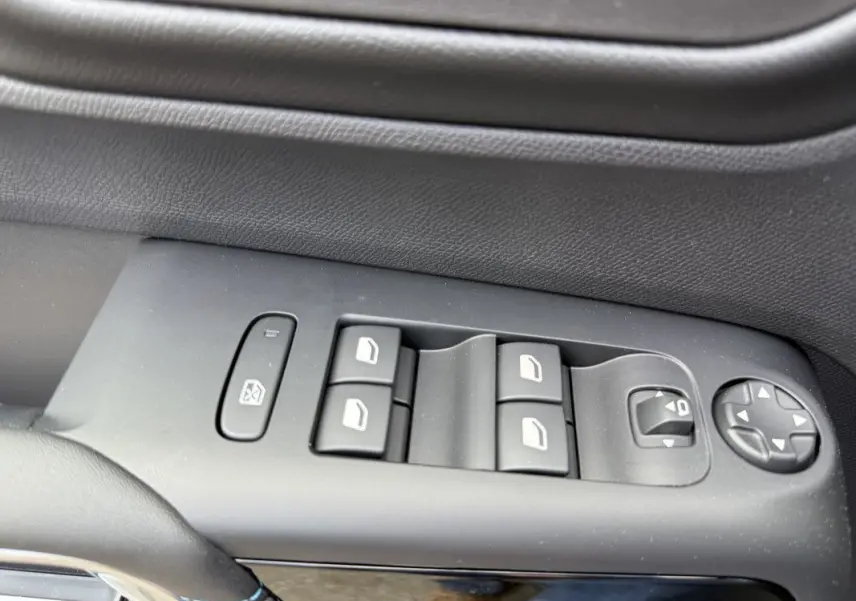 Gros plan sur les commandes de lève-vitres et rétroviseurs côté conducteur du Citroën C5 Aircross gris platinium 2025.