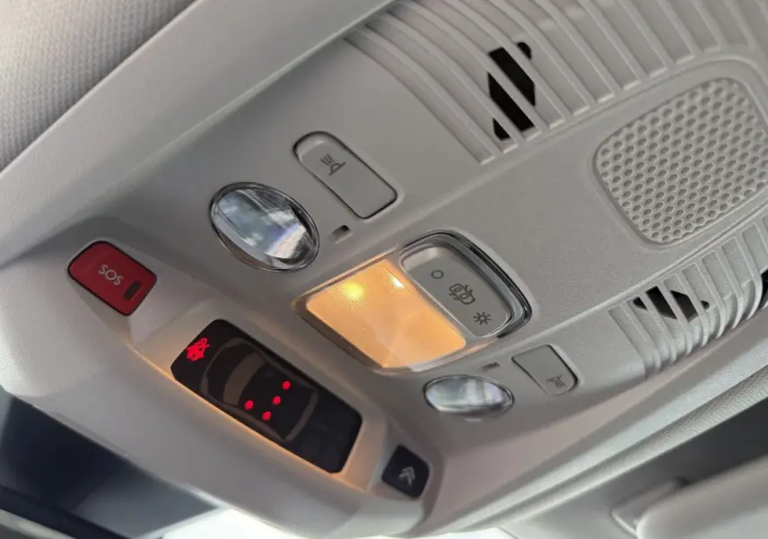 Vue en gros plan du plafonnier gris platinium du Citroën C5 Aircross 2025 avec éclairage intérieur et bouton SOS rouge.