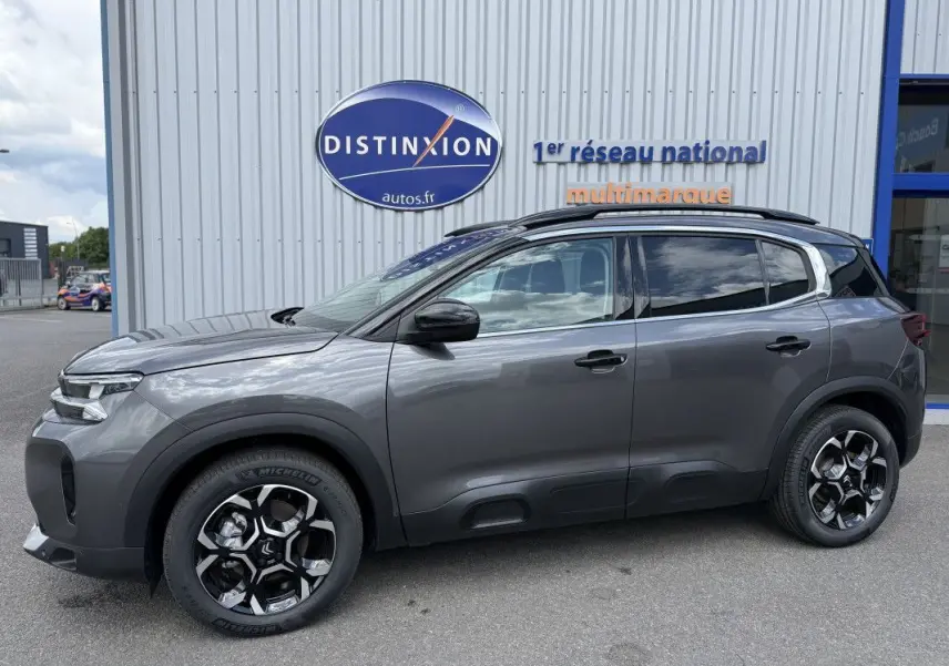 Vue de profil côté gauche d’un Citroën C5 Aircross gris platinium métallisé avec jantes noires et toit noir.