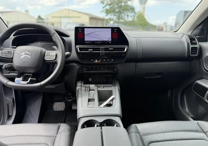 Vue intérieure avant du Citroën C5 Aircross 2025, tableau de bord noir avec écran tactile central et volant multifonction.