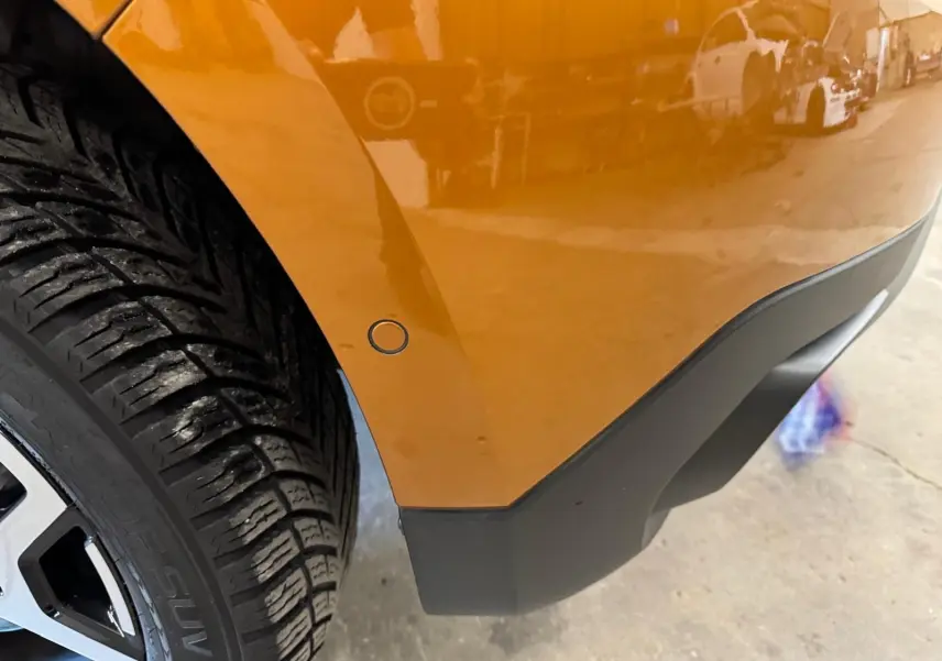 Détail de l’aile arrière droite orange du Dacia Duster 2020 avec roue et pare-chocs noir mat visible.