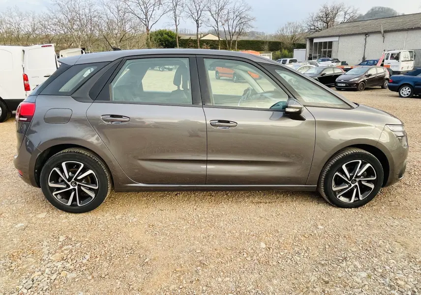 Profil côté gauche d'une Citroën C4 Picasso gris métal 2018 avec jantes alliage et lignes de carrosserie marquées.