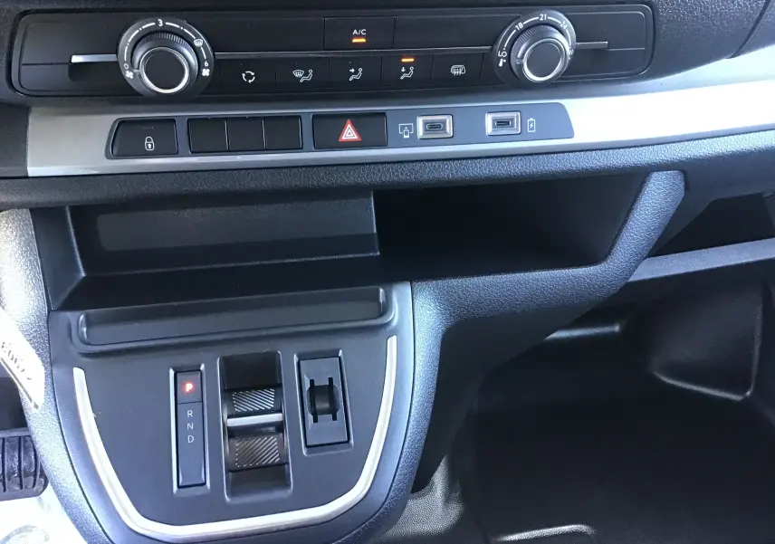 Vue rapprochée de la console centrale du Citroën Jumpy XL gris titane, montrant la commande de boîte automatique et les réglages climatisation.