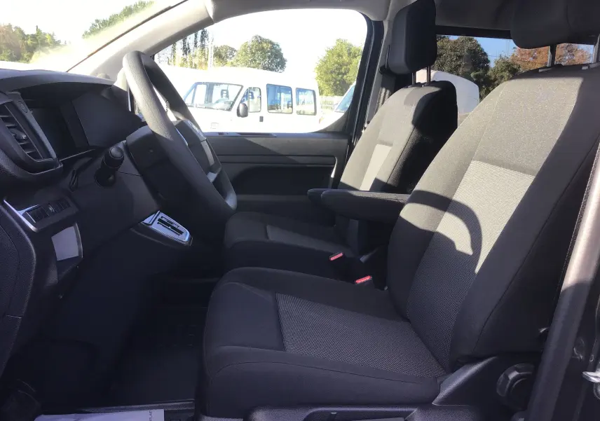 Vue intérieure côté conducteur du Citroën Jumpy XL gris titane, montrant les sièges avant et le volant.
