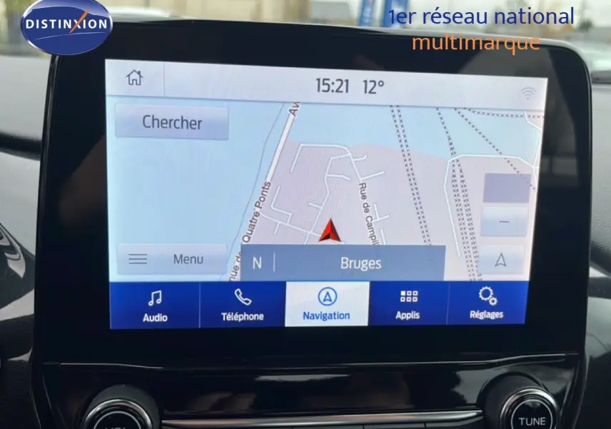 Écran tactile central du Ford Puma 2024 montrant la navigation sur Bruges, avec commandes audio et téléphone visibles.