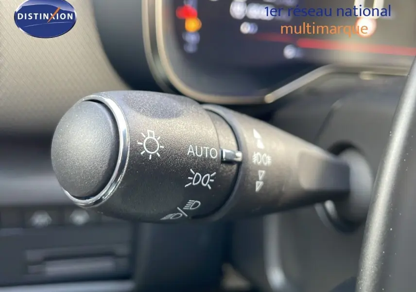 Gros plan sur la commande des phares à gauche du volant dans l’habitacle du Citroën C5 Aircross bleu Eclipse Metal.