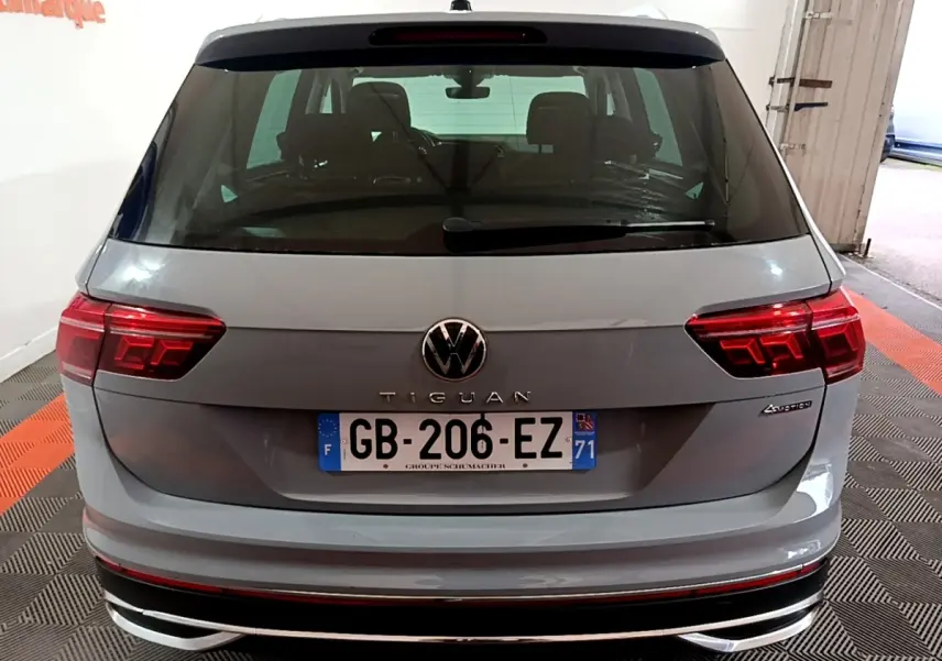 Vue arrière d'un Volkswagen Tiguan gris foncé avec feux LED et logo VW bien visibles dans un garage.