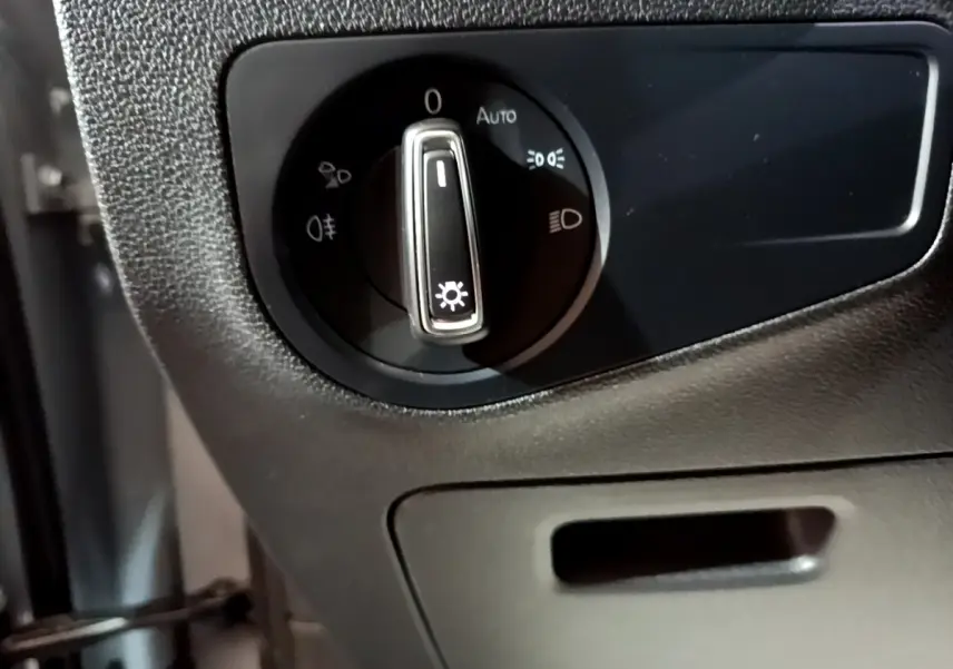 Gros plan sur la commande des phares dans l'habitacle noir du Volkswagen Tiguan gris foncé 2021.