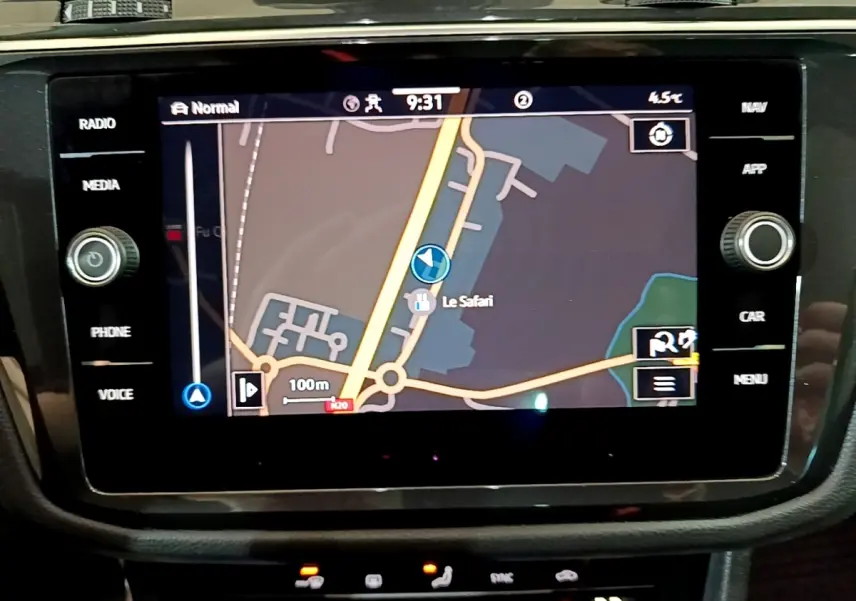 Écran tactile central du Volkswagen Tiguan 2021 affichant la navigation avec carte et commandes autour en noir brillant.