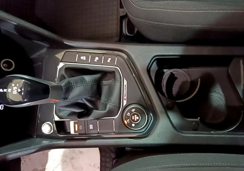 Vue plongeante sur la console centrale du Volkswagen Tiguan gris foncé, avec levier de vitesses DSG7 et commandes 4Motion.