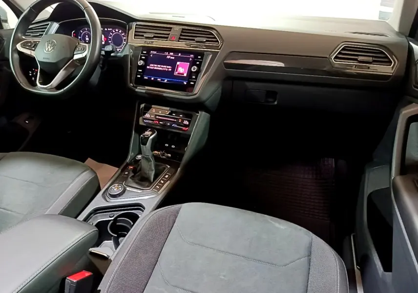Intérieur du Volkswagen Tiguan 2.0 TDI 2021, vue côté conducteur sur tableau de bord et console centrale noire.