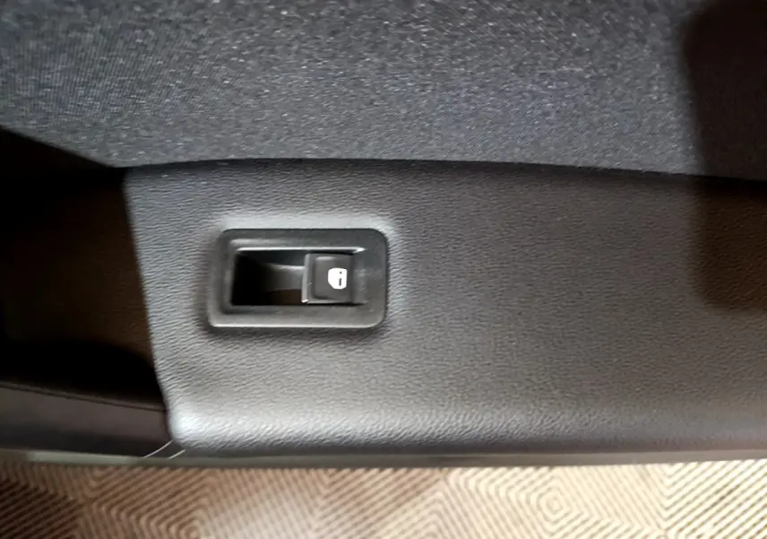 Bouton de verrouillage des portes sur la garniture intérieure noire d'une Volkswagen Tiguan gris foncé 2021.