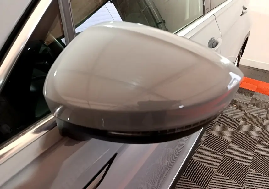 Gros plan sur le rétroviseur droit gris foncé du Volkswagen Tiguan 2021 avec clignotant intégré et carrosserie visible.