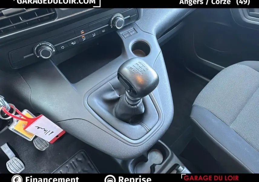 Intérieur du Peugeot Rifter 2024 bleu, vue rapprochée sur la boîte manuelle et la console centrale noire.