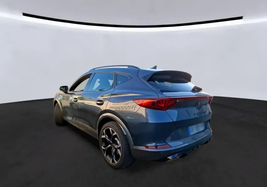 Vue 3/4 arrière droite d'un CUPRA Formentor gris foncé 2023, avec feux arrière allongés et jantes noires sportives.