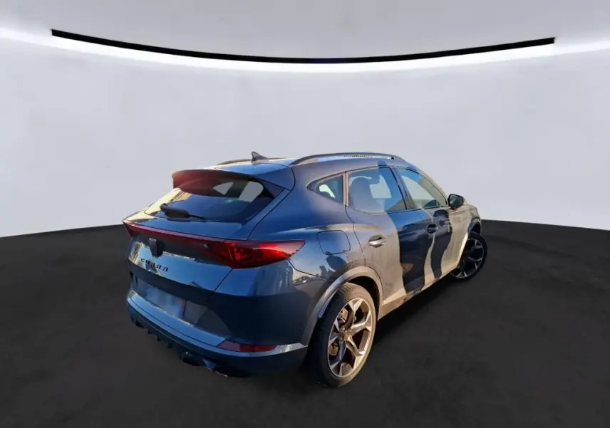 Vue 3/4 arrière droite d'un CUPRA Formentor gris foncé 2023 avec jantes alliage et toit ouvrant.