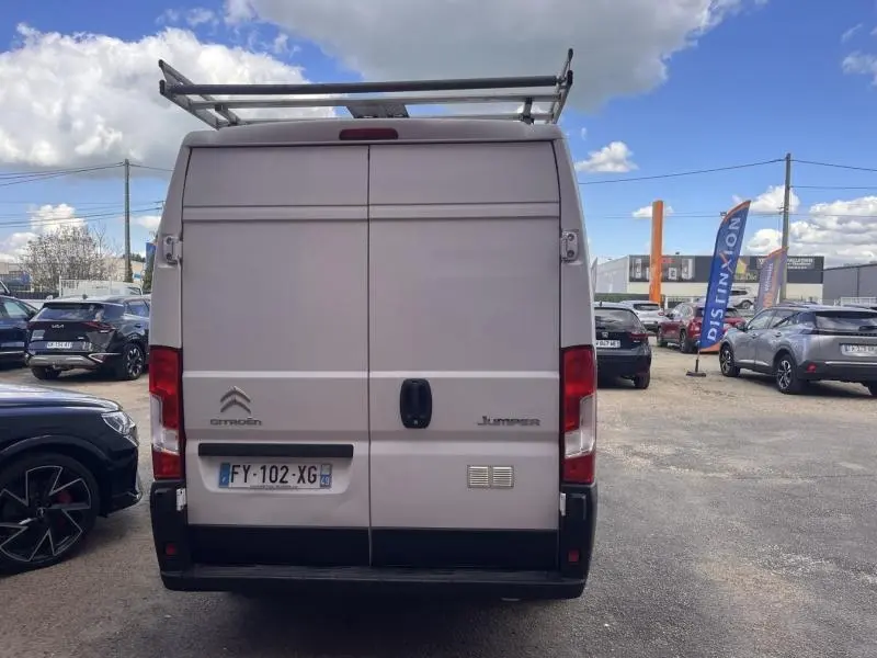 Vue arrière d’un Citroën Jumper blanc Icy avec portes battantes et galerie de toit métallique.