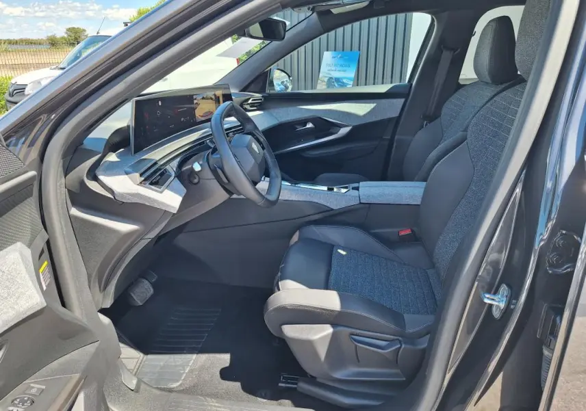 Vue intérieure côté conducteur du Peugeot 3008 Hybrid 136 gris foncé, avec sièges bi-matière et cockpit numérique.