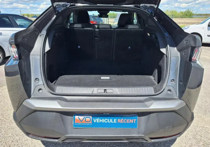 Vue arrière du coffre ouvert d’un Peugeot 3008 gris foncé, montrant l’espace de chargement et les feux arrière.