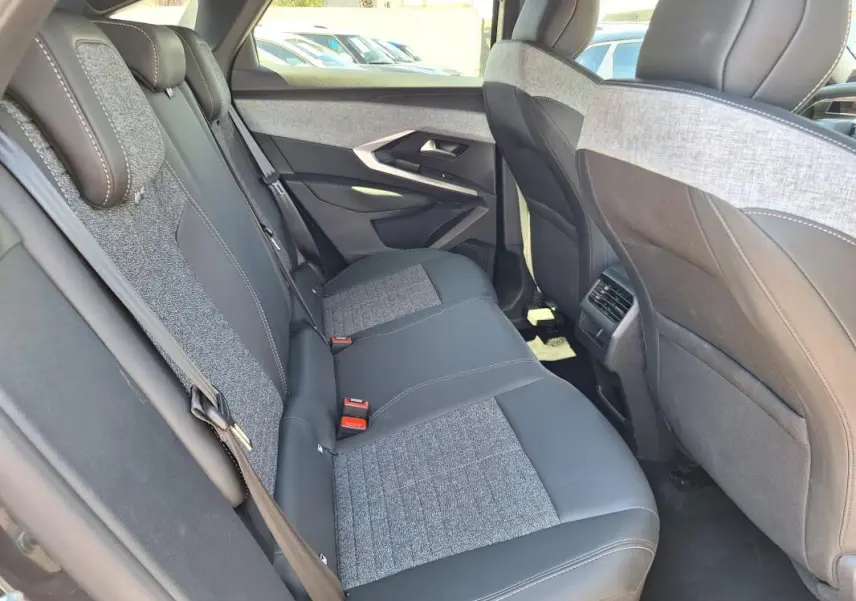Vue intérieure côté droit des sièges arrière en tissu gris et cuir noir du Peugeot 3008 Hybrid 136 e-DCS6 Allure 2025.