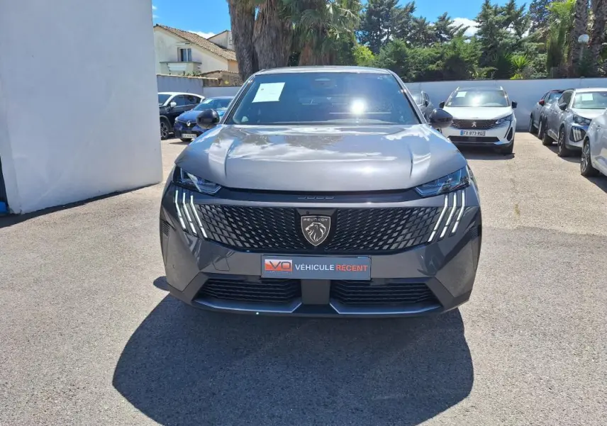 Vue frontale d'un Peugeot 3008 Hybrid gris foncé avec calandre noire et feux LED verticaux distinctifs.
