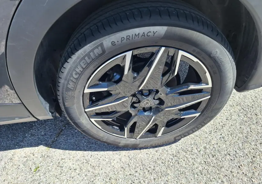 Gros plan sur la jante alliage 19 pouces noire et argentée du côté avant gauche du Peugeot 3008 Hybrid gris foncé.